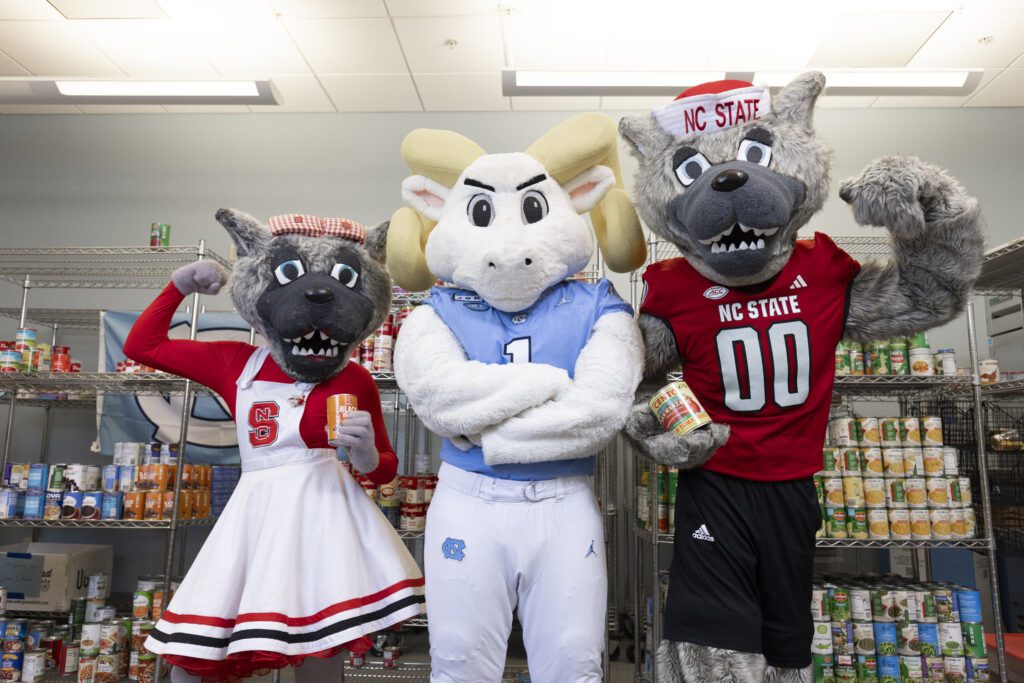 Carolina and NC State mascots posed looking forward.