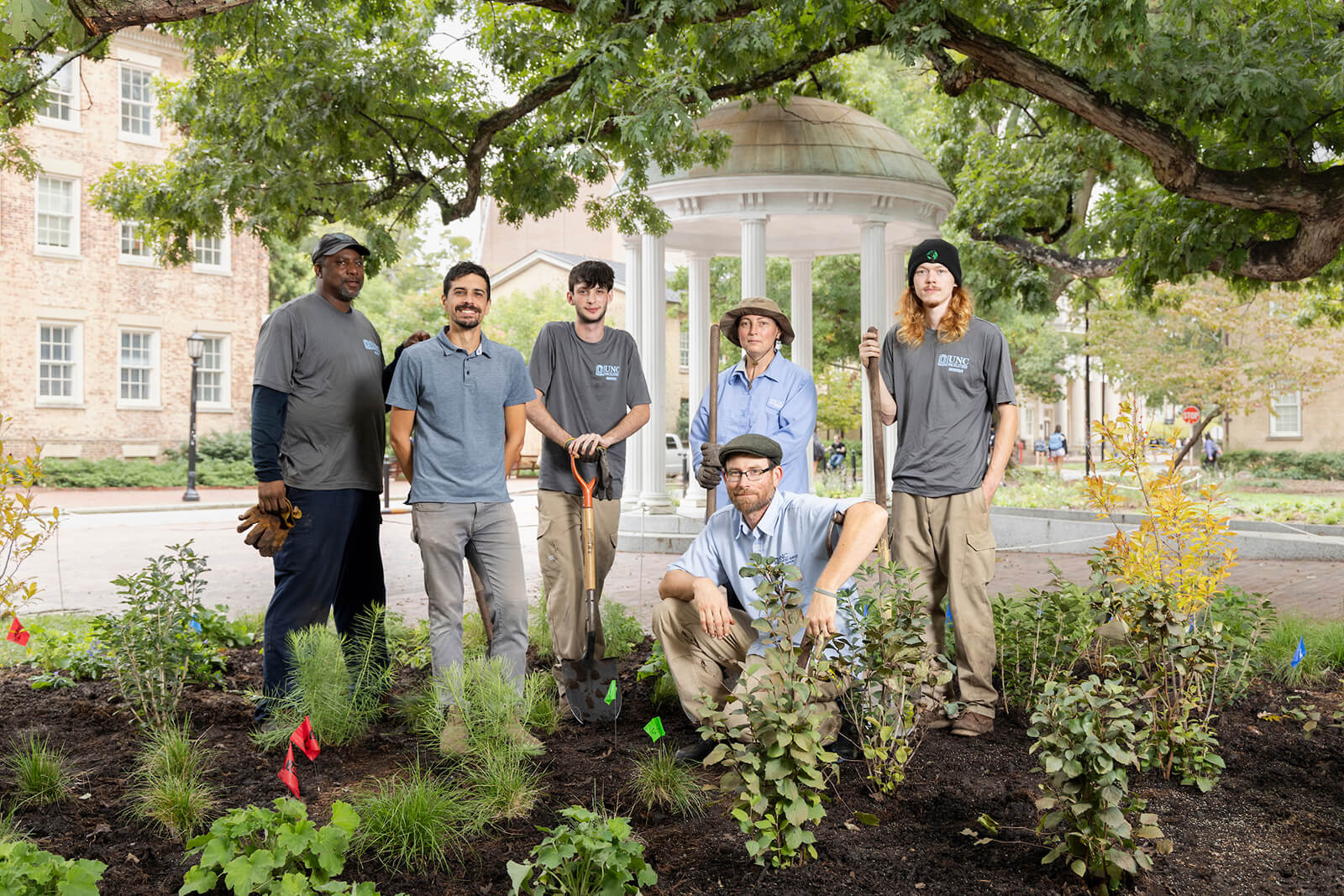 University Landscape Architect Dan Widis standing with 5 members of the groundskeeping team at UNC-Chapel Hill in front of the Old Well.