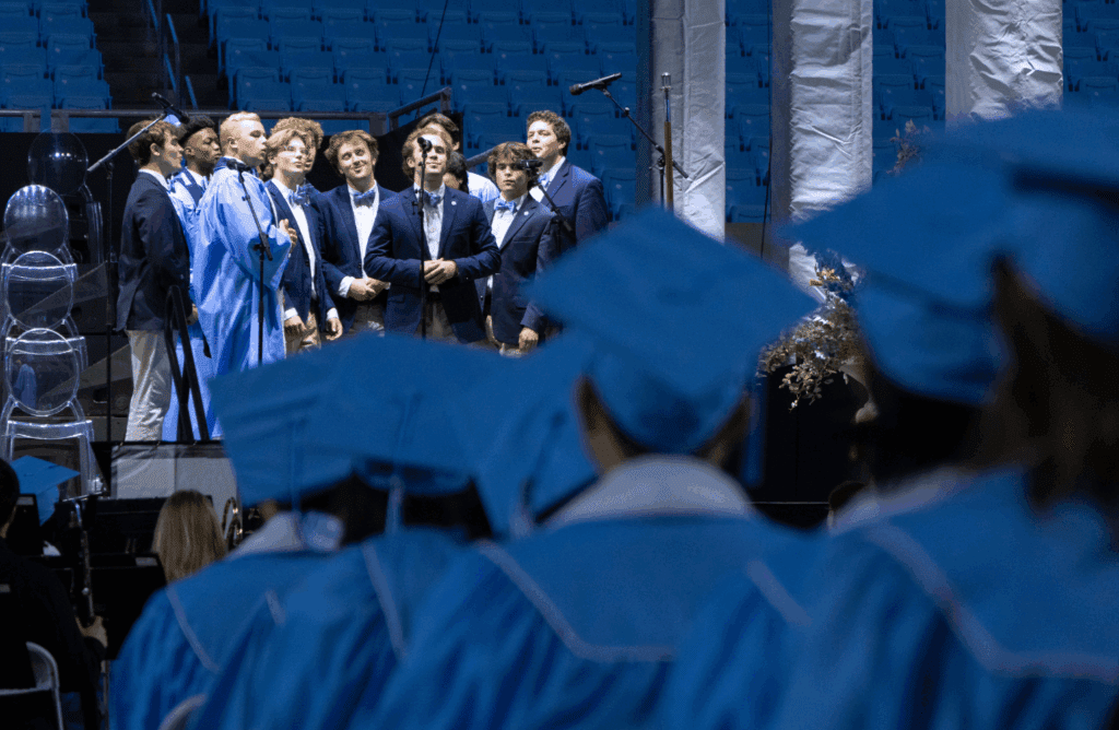 UNC Clef Hangers singing "Carolina on my Mind" in front of a microphone.