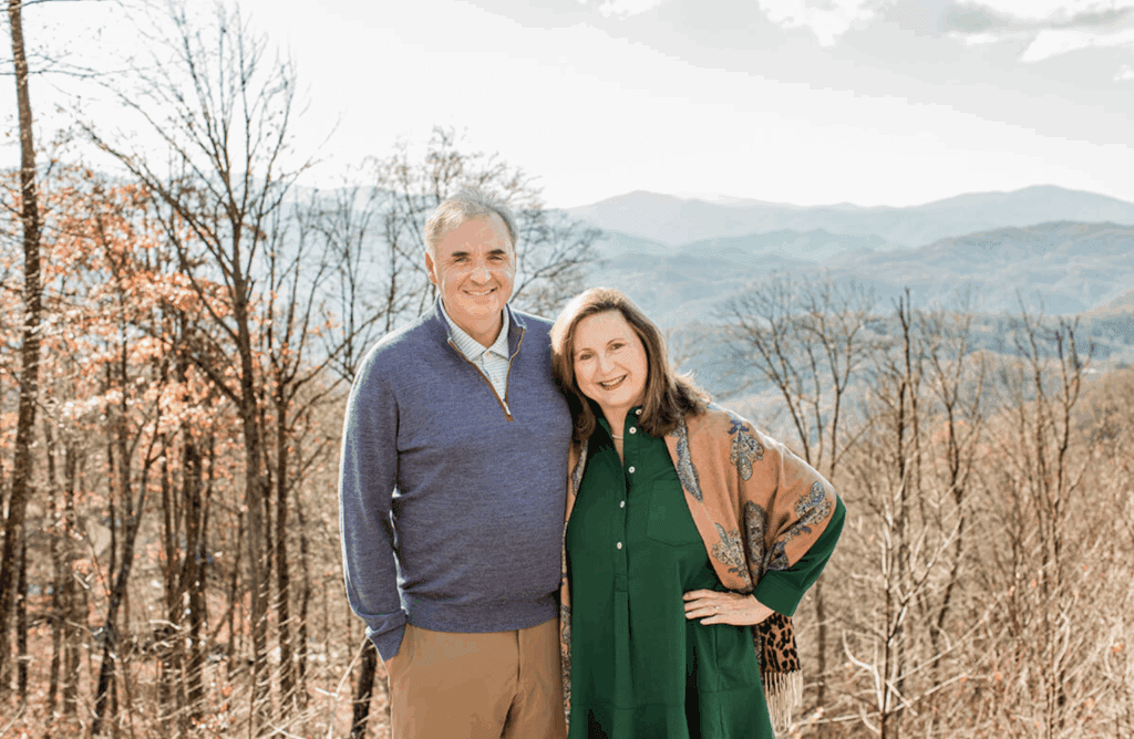 Class of 1987 alumni Dwight and Moira Jacobs smiling together in front of the mountains