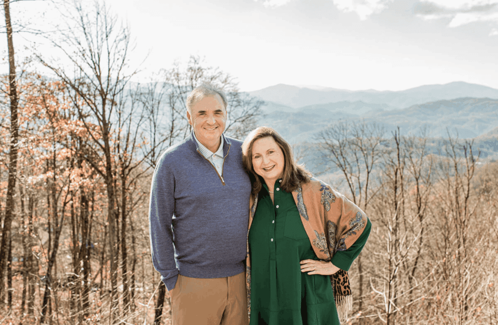 Class of 1987 alumni Dwight and Moira Jacobs smiling together in front of the mountains