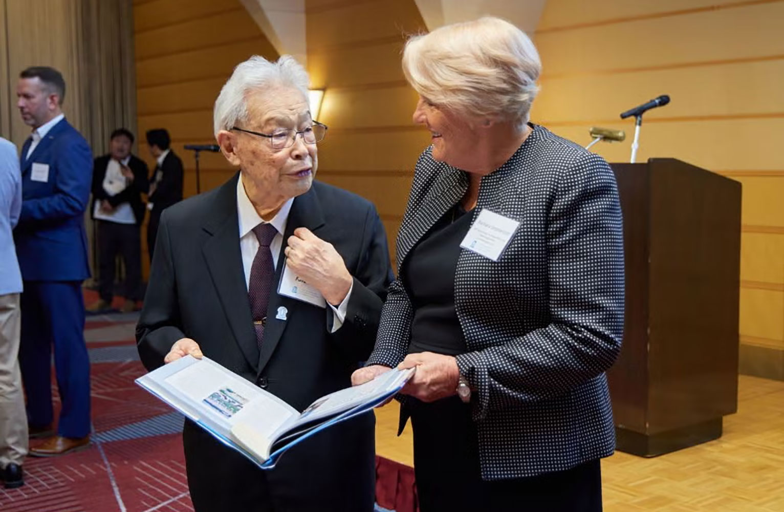 Barbara Stephenson presents Taketo "Mike" Furuhata with a book at the SEUS Japan conference.