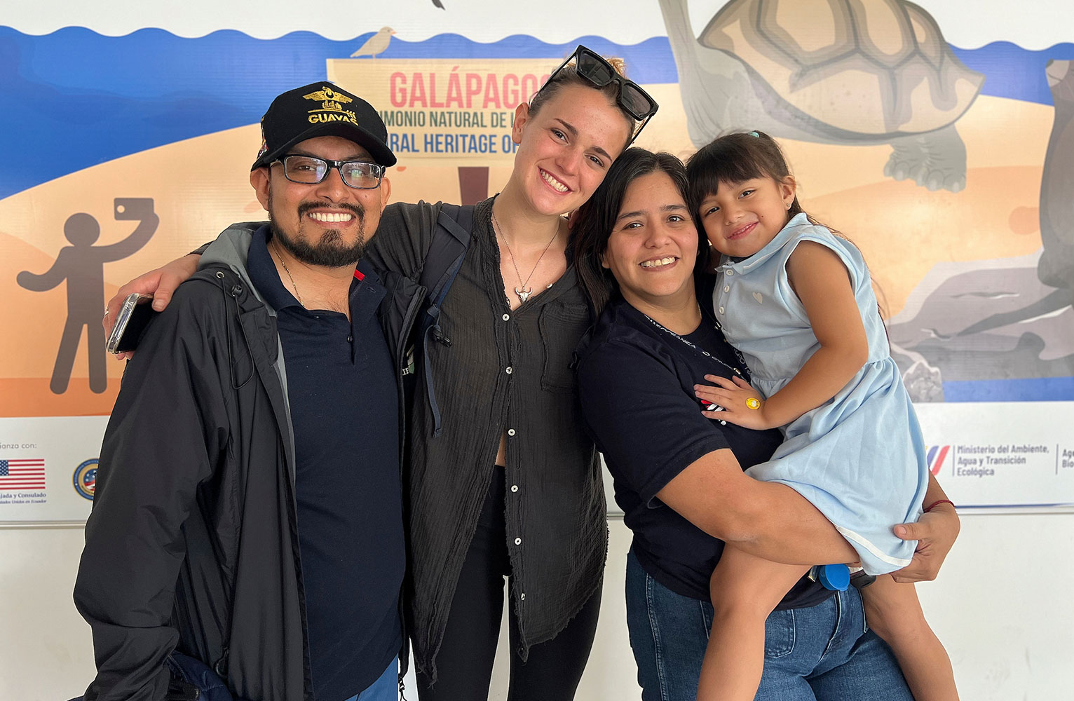 Maya True Wasik poses with her Galapagos host family, a father, mother and child.