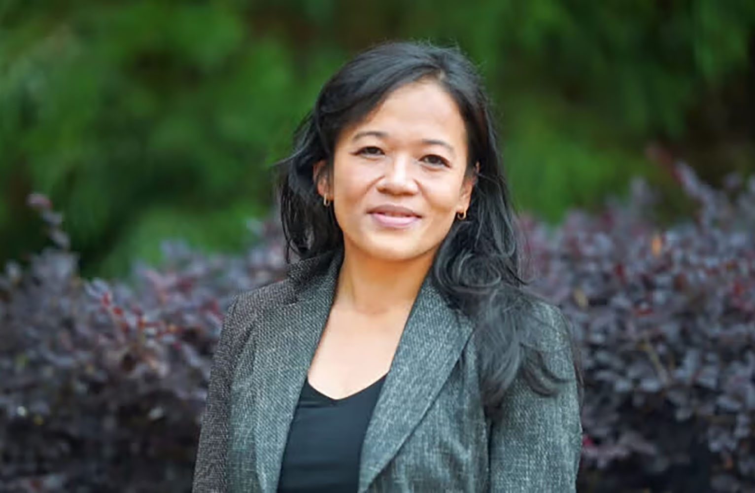 Juliane Nguyen poses for the camera with plants in the background