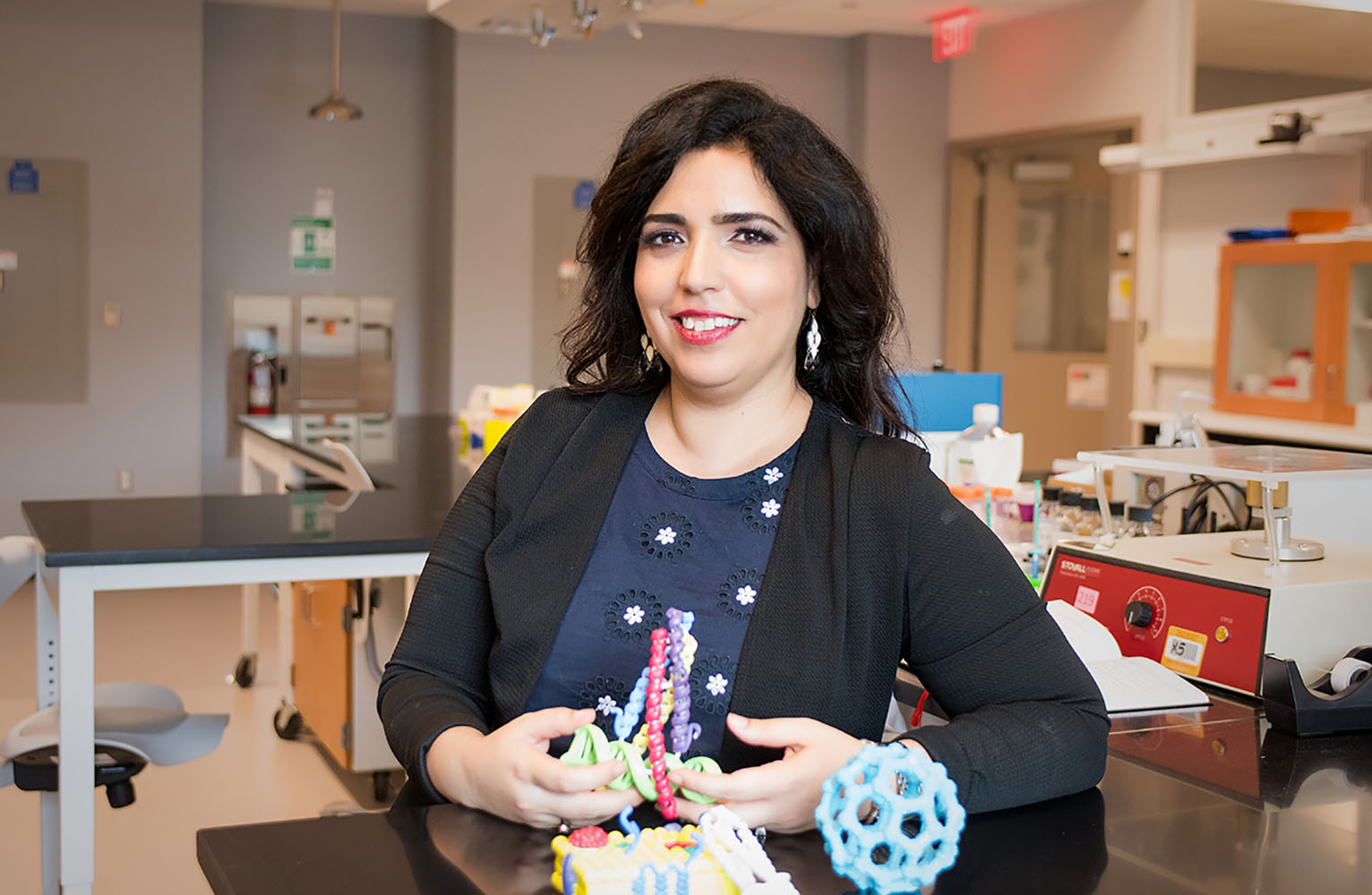 Ronit Freeman poses for the camera with her lab in the background.