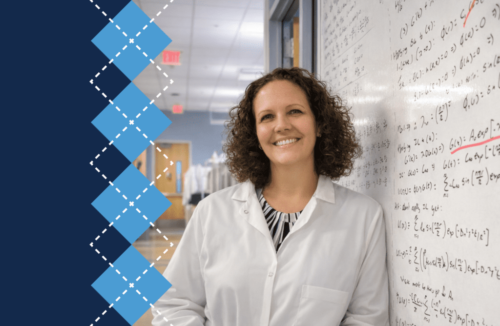 Kristy Ainslie leans against a whiteboard covered with words; her photo is set on a navy background and UNC-branded argyle running vertically down the first third of the frame